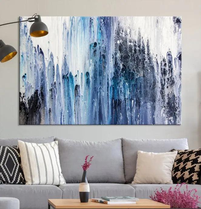 The minimalist room is adorned with the Ink Abstract Wall Art Canvas Print, featuring a museum-quality triptych in blue and white elegantly displayed. Rendered on UV-protective canvas for lasting vibrancy.