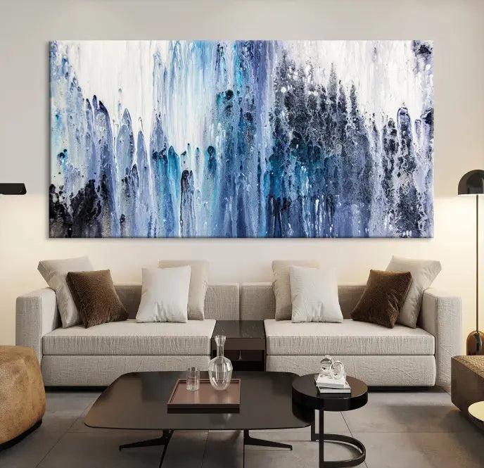 The minimalist room is adorned with the Ink Abstract Wall Art Canvas Print, featuring a museum-quality triptych in blue and white elegantly displayed. Rendered on UV-protective canvas for lasting vibrancy.