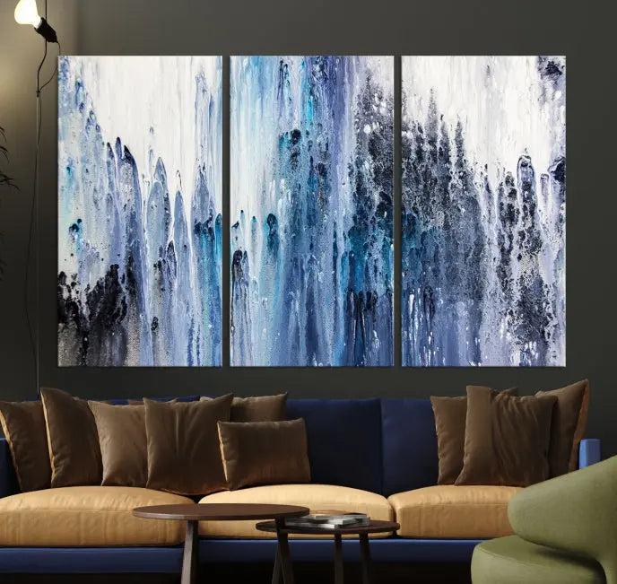 The minimalist room is adorned with the Ink Abstract Wall Art Canvas Print, featuring a museum-quality triptych in blue and white elegantly displayed. Rendered on UV-protective canvas for lasting vibrancy.