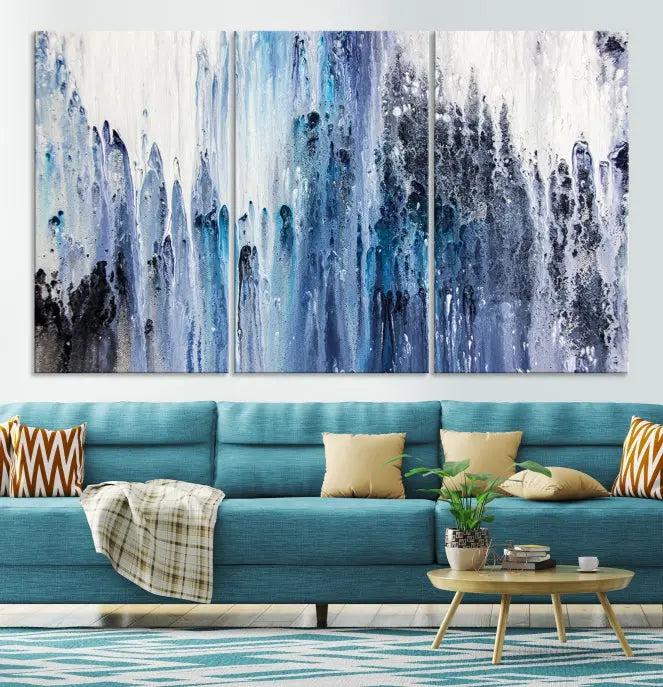 The minimalist room is adorned with the Ink Abstract Wall Art Canvas Print, featuring a museum-quality triptych in blue and white elegantly displayed. Rendered on UV-protective canvas for lasting vibrancy.