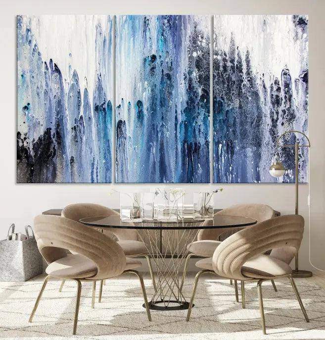 The minimalist room is adorned with the Ink Abstract Wall Art Canvas Print, featuring a museum-quality triptych in blue and white elegantly displayed. Rendered on UV-protective canvas for lasting vibrancy.