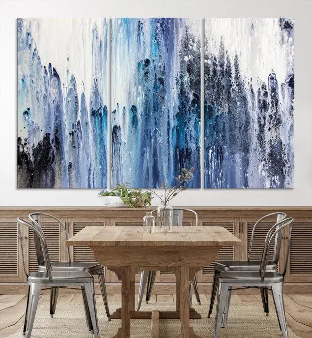 The minimalist room is adorned with the Ink Abstract Wall Art Canvas Print, featuring a museum-quality triptych in blue and white elegantly displayed. Rendered on UV-protective canvas for lasting vibrancy.