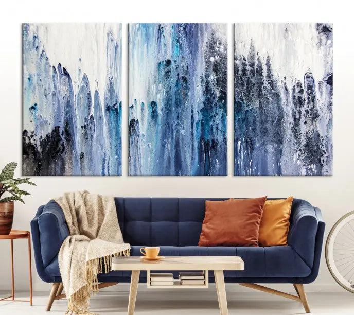 The minimalist room is adorned with the Ink Abstract Wall Art Canvas Print, featuring a museum-quality triptych in blue and white elegantly displayed. Rendered on UV-protective canvas for lasting vibrancy.