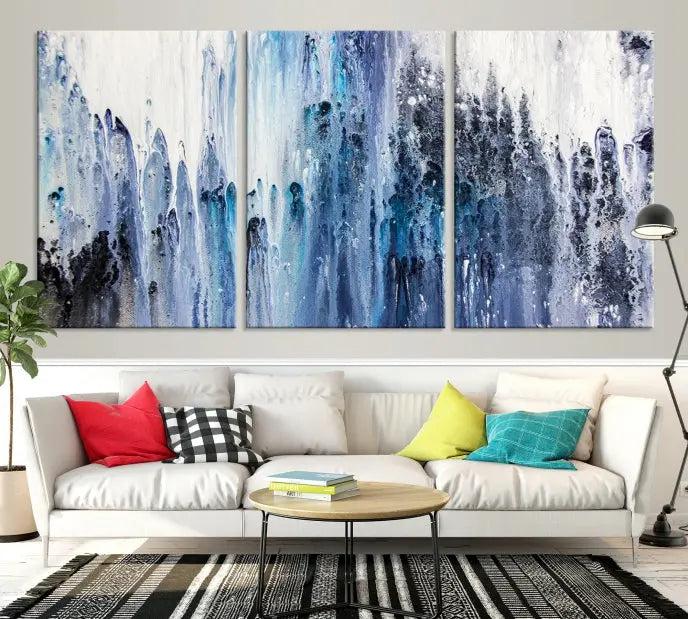 The minimalist room is adorned with the Ink Abstract Wall Art Canvas Print, featuring a museum-quality triptych in blue and white elegantly displayed. Rendered on UV-protective canvas for lasting vibrancy.