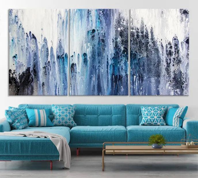 The minimalist room is adorned with the Ink Abstract Wall Art Canvas Print, featuring a museum-quality triptych in blue and white elegantly displayed. Rendered on UV-protective canvas for lasting vibrancy.