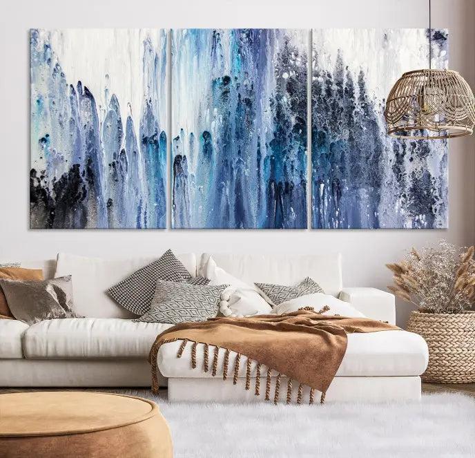 The minimalist room is adorned with the Ink Abstract Wall Art Canvas Print, featuring a museum-quality triptych in blue and white elegantly displayed. Rendered on UV-protective canvas for lasting vibrancy.