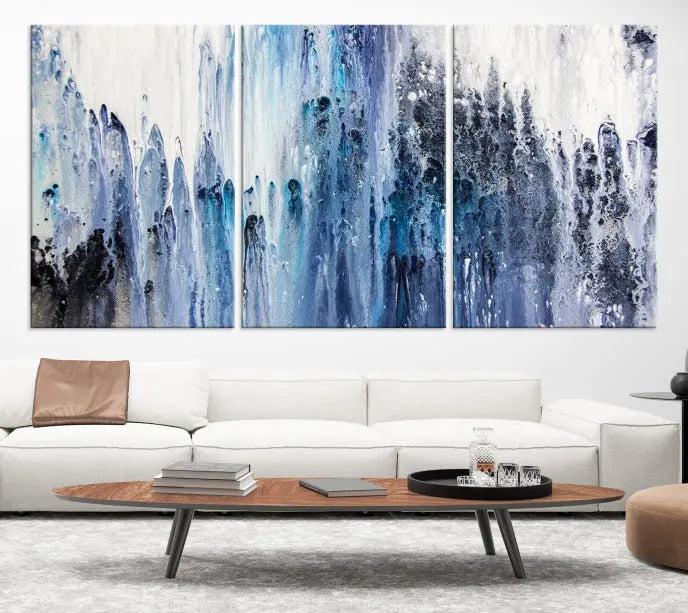 The minimalist room is adorned with the Ink Abstract Wall Art Canvas Print, featuring a museum-quality triptych in blue and white elegantly displayed. Rendered on UV-protective canvas for lasting vibrancy.