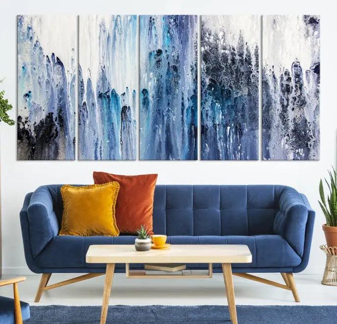 The minimalist room is adorned with the Ink Abstract Wall Art Canvas Print, featuring a museum-quality triptych in blue and white elegantly displayed. Rendered on UV-protective canvas for lasting vibrancy.