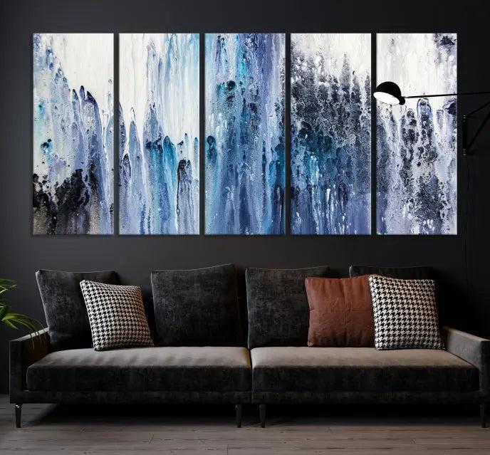 The minimalist room is adorned with the Ink Abstract Wall Art Canvas Print, featuring a museum-quality triptych in blue and white elegantly displayed. Rendered on UV-protective canvas for lasting vibrancy.