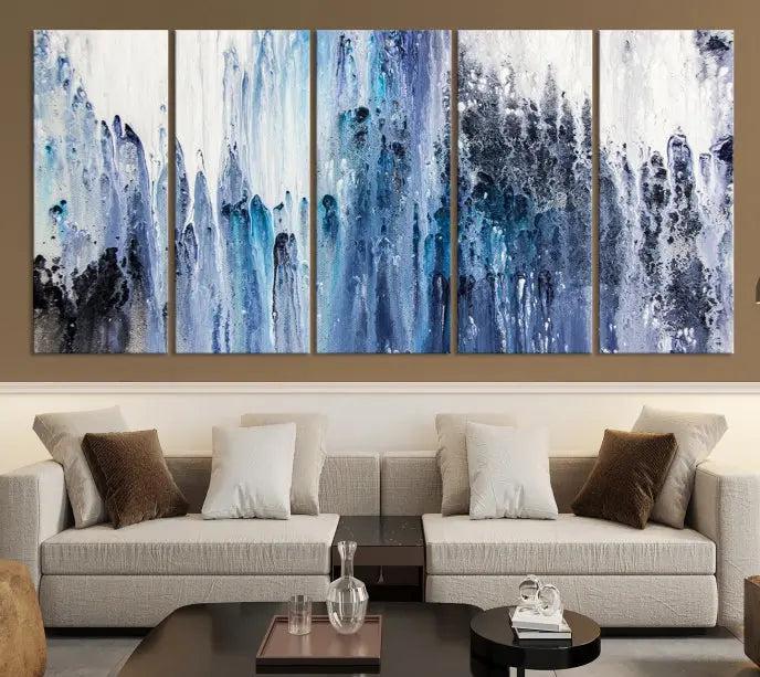 The minimalist room is adorned with the Ink Abstract Wall Art Canvas Print, featuring a museum-quality triptych in blue and white elegantly displayed. Rendered on UV-protective canvas for lasting vibrancy.