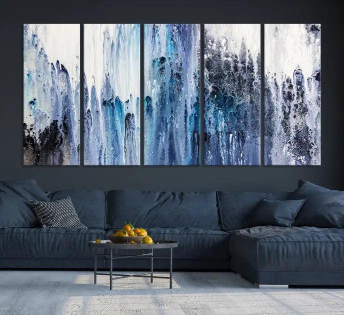 The minimalist room is adorned with the Ink Abstract Wall Art Canvas Print, featuring a museum-quality triptych in blue and white elegantly displayed. Rendered on UV-protective canvas for lasting vibrancy.