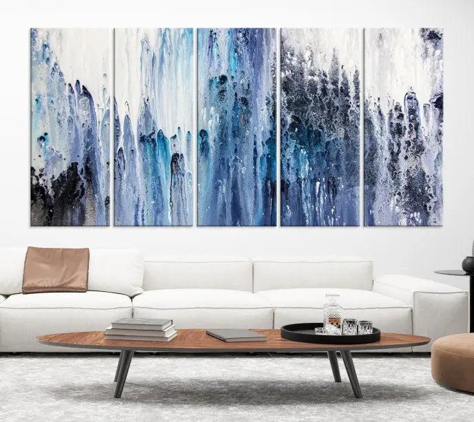 The minimalist room is adorned with the Ink Abstract Wall Art Canvas Print, featuring a museum-quality triptych in blue and white elegantly displayed. Rendered on UV-protective canvas for lasting vibrancy.