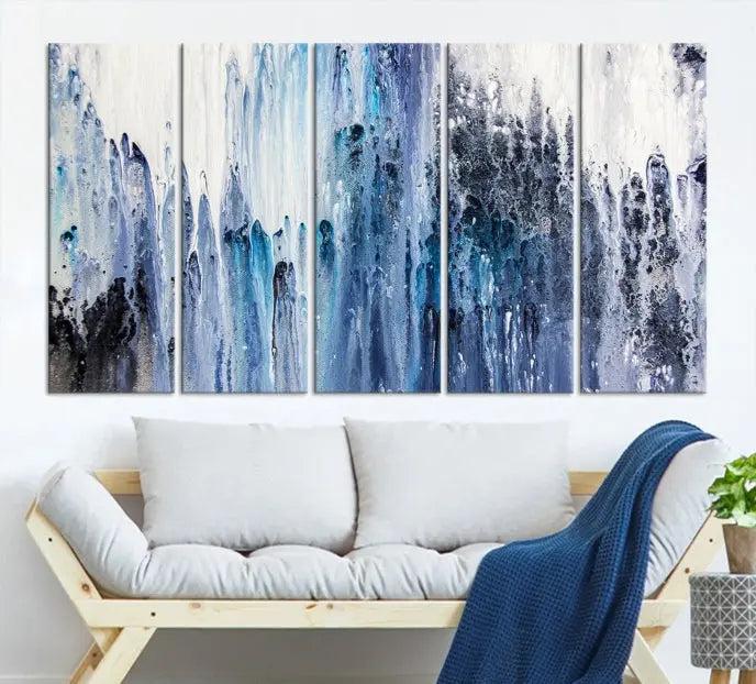 The minimalist room is adorned with the Ink Abstract Wall Art Canvas Print, featuring a museum-quality triptych in blue and white elegantly displayed. Rendered on UV-protective canvas for lasting vibrancy.