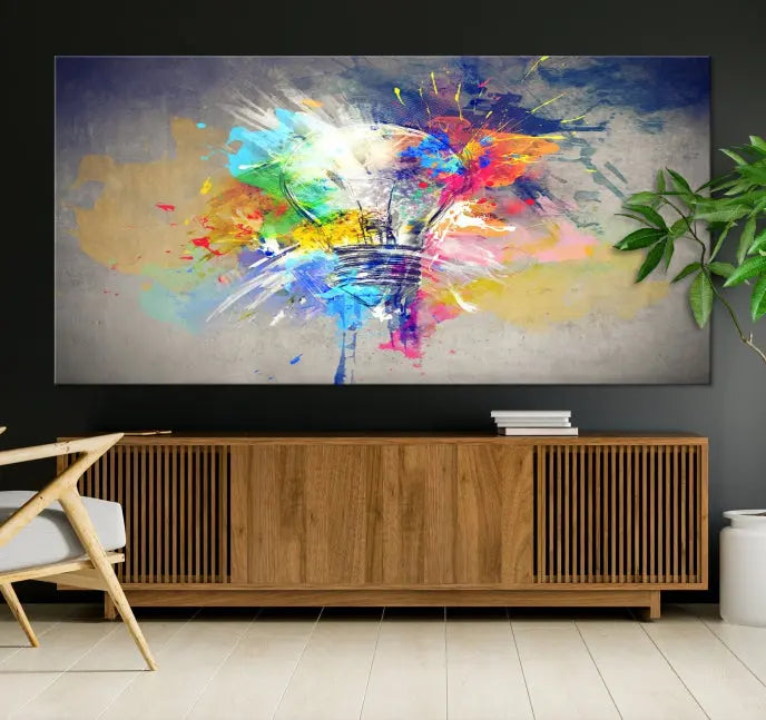 The Lamp Abstract Color Wall Art Canvas Print showcases vibrant splashes of color around a light bulb design. This museum-quality canvas comes ready to hang and features a UV-protective coating to keep its colors vivid and striking for years.