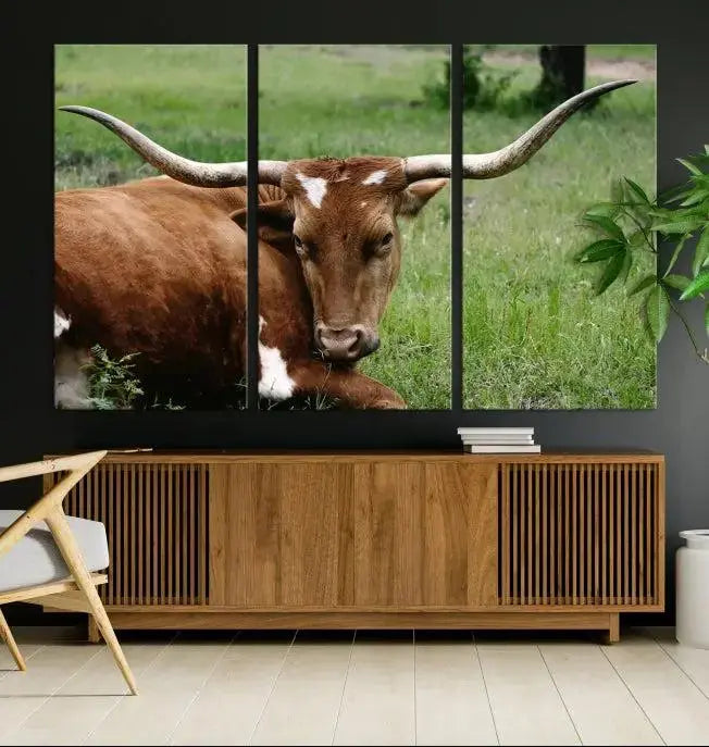 A triptych of the Longhorn Cow Animal Wall Art Canvas Print adorns the wall. These museum-quality canvases are gallery-wrapped and finished with a UV-protective coating for lasting beauty.