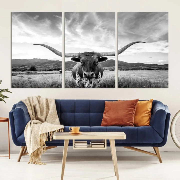 A modern living room showcases a black and white triptych of the "Longhorn Cow Wall Art Canvas Print Farmhouse Wall Art Texas longhorn wall art.