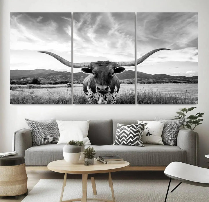 A modern living room showcases a black and white triptych of the "Longhorn Cow Wall Art Canvas Print Farmhouse Wall Art Texas longhorn wall art.