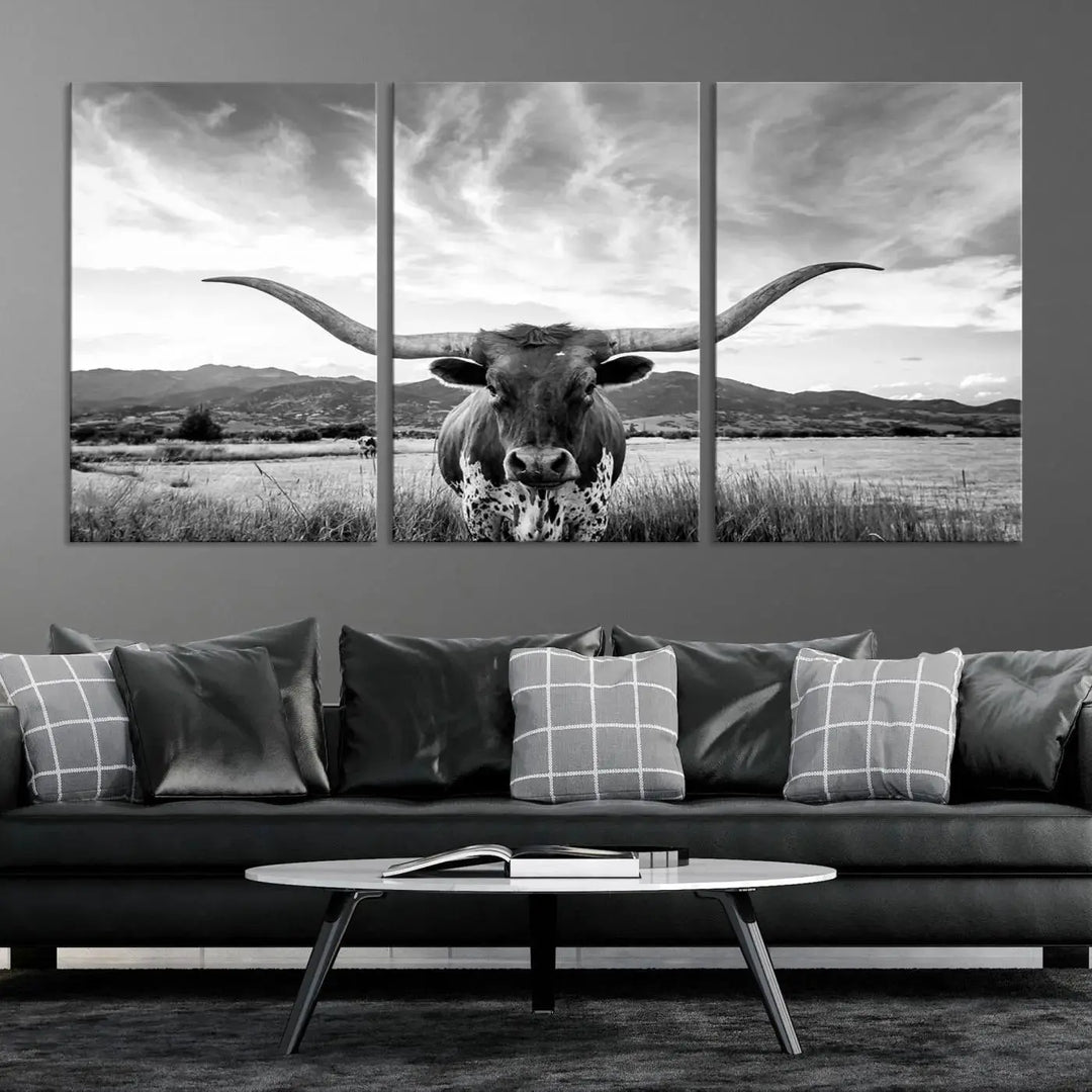 A modern living room showcases a black and white triptych of the "Longhorn Cow Wall Art Canvas Print Farmhouse Wall Art Texas longhorn wall art.