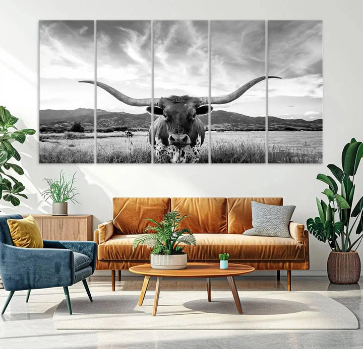 A modern living room showcases a black and white triptych of the "Longhorn Cow Wall Art Canvas Print Farmhouse Wall Art Texas longhorn wall art.