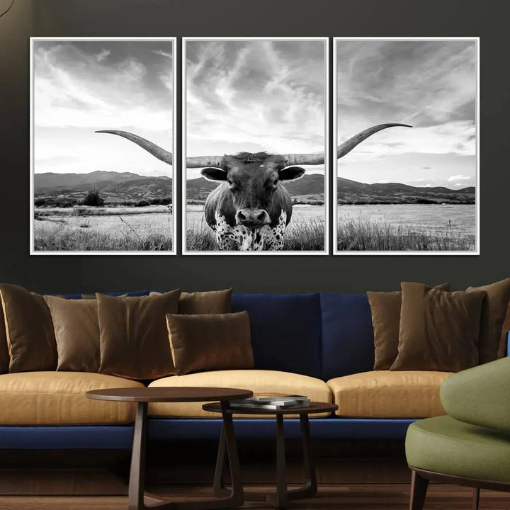 A modern living room showcases a black and white triptych of the "Longhorn Cow Wall Art Canvas Print Farmhouse Wall Art Texas longhorn wall art.