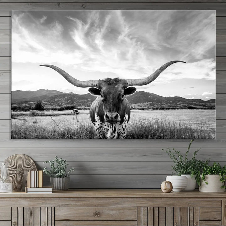 A modern living room showcases a black and white triptych of the "Longhorn Cow Wall Art Canvas Print Farmhouse Wall Art Texas longhorn wall art.