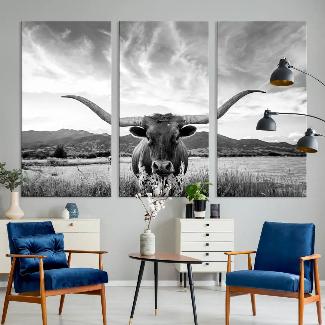 A modern living room showcases a black and white triptych of the "Longhorn Cow Wall Art Canvas Print Farmhouse Wall Art Texas longhorn wall art.