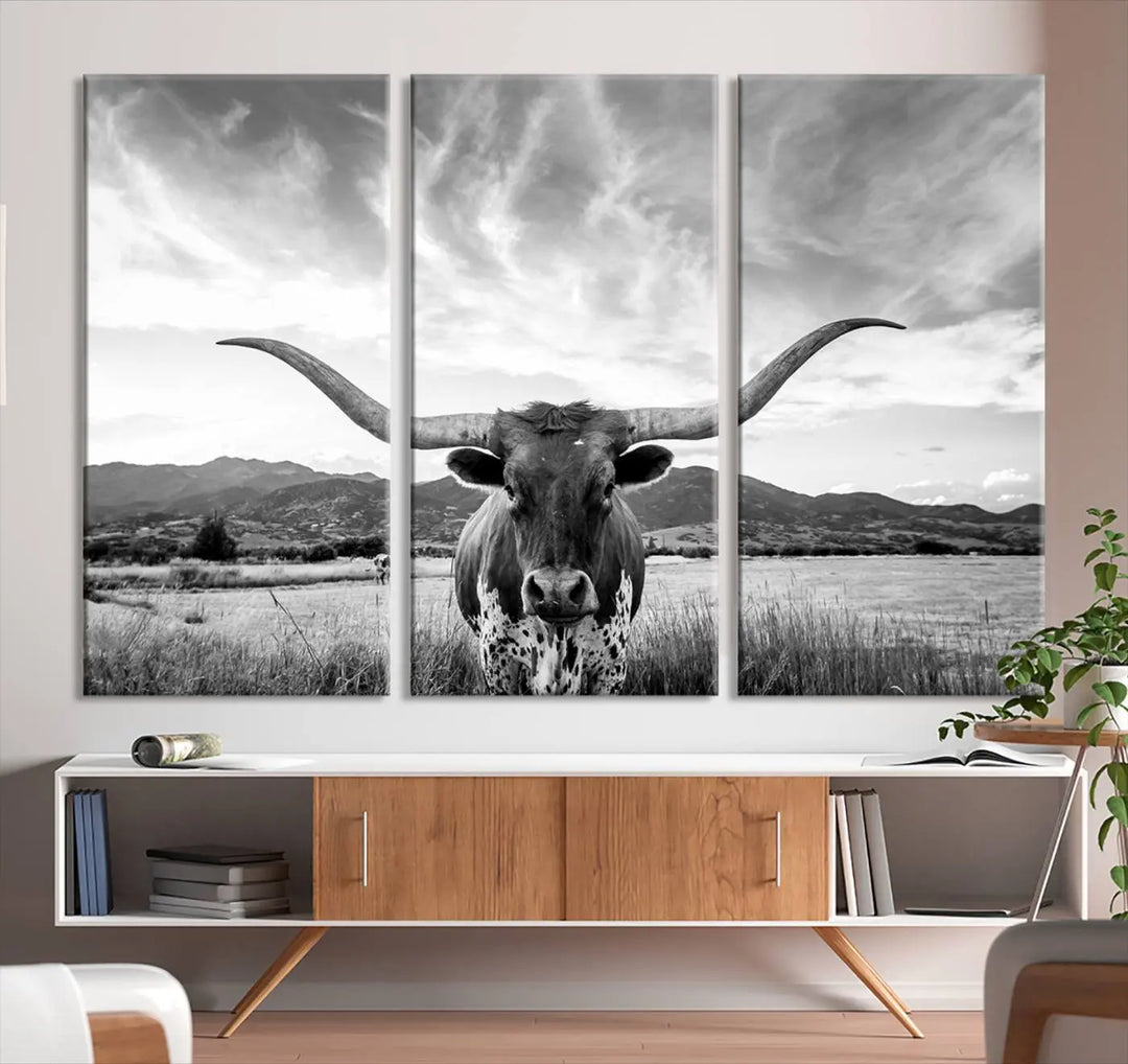 A modern living room showcases a black and white triptych of the "Longhorn Cow Wall Art Canvas Print Farmhouse Wall Art Texas longhorn wall art.