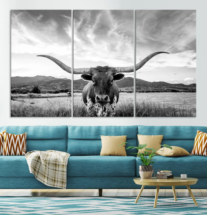 A modern living room showcases a black and white triptych of the "Longhorn Cow Wall Art Canvas Print Farmhouse Wall Art Texas longhorn wall art.