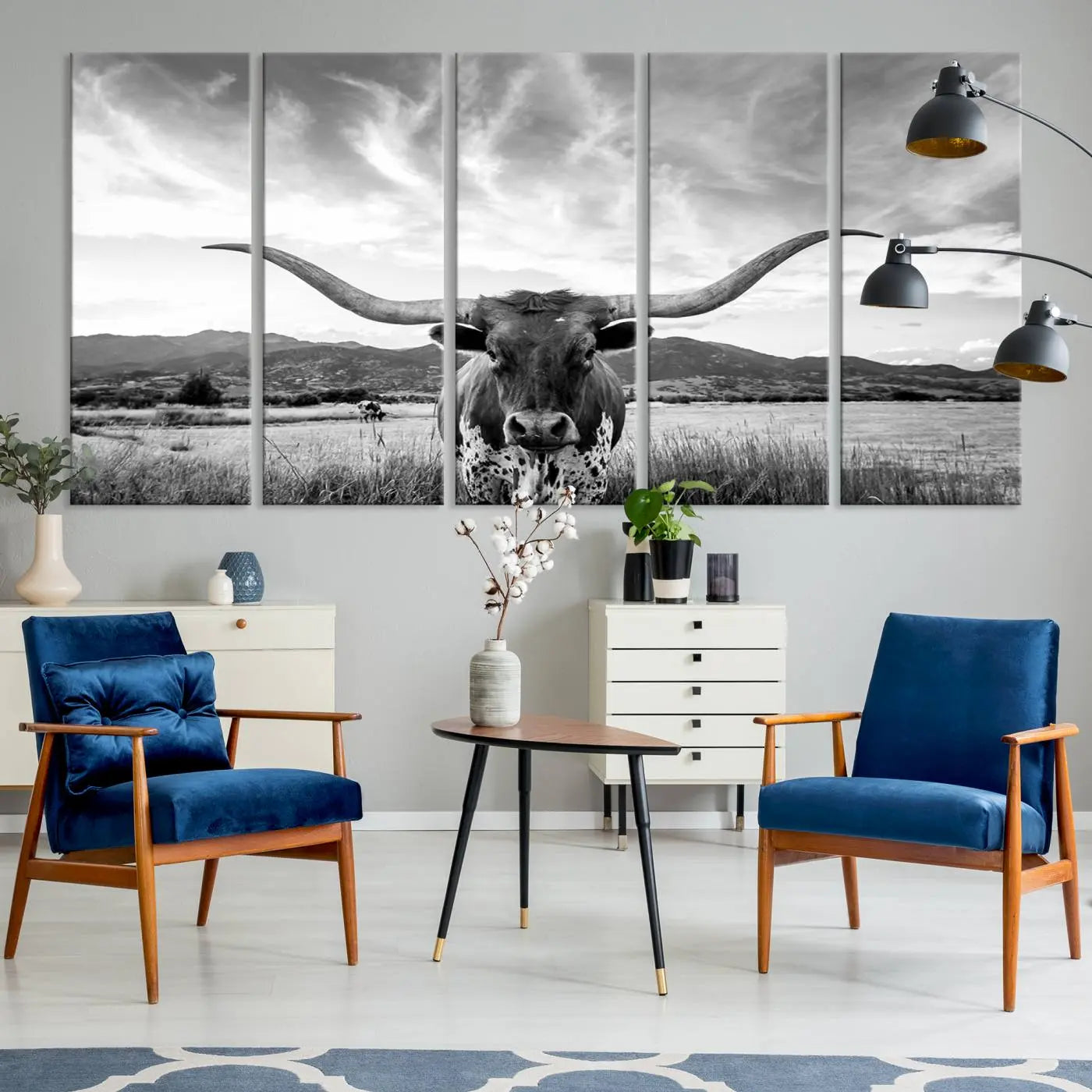 A modern living room showcases a black and white triptych of the 