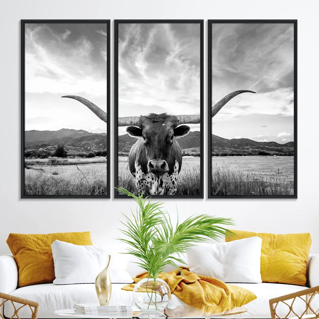 A modern living room showcases a black and white triptych of the "Longhorn Cow Wall Art Canvas Print Farmhouse Wall Art Texas longhorn wall art.