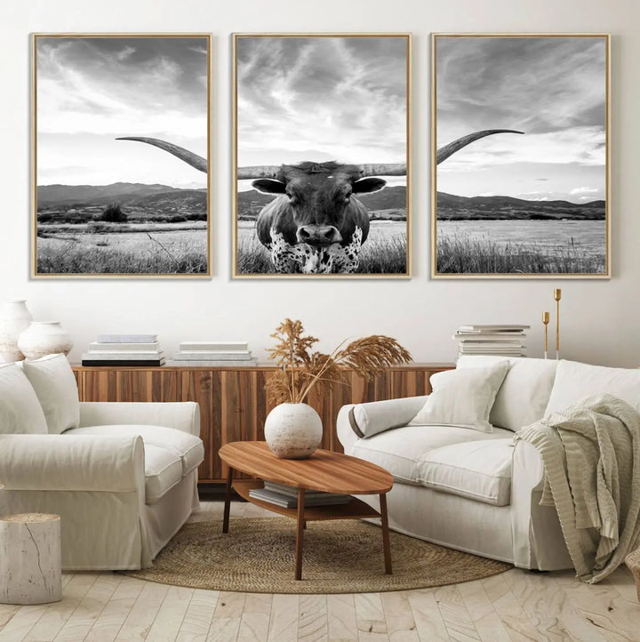 A modern living room showcases a black and white triptych of the "Longhorn Cow Wall Art Canvas Print Farmhouse Wall Art Texas longhorn wall art.