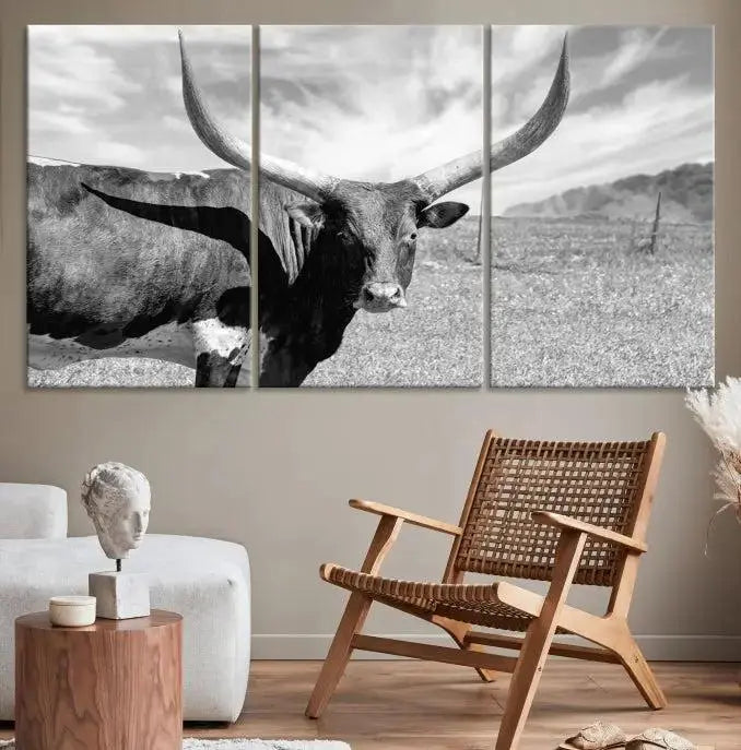 The Longhorn Wall Art Canvas Print, a black and white triptych of a longhorn cow in a grassy field, is elegantly displayed on museum-quality canvases.