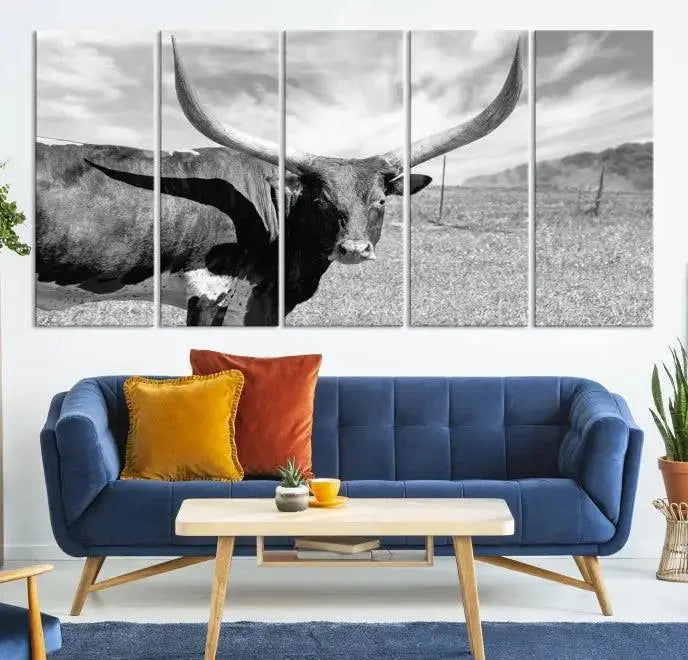 The Longhorn Wall Art Canvas Print, a black and white triptych of a longhorn cow in a grassy field, is elegantly displayed on museum-quality canvases.