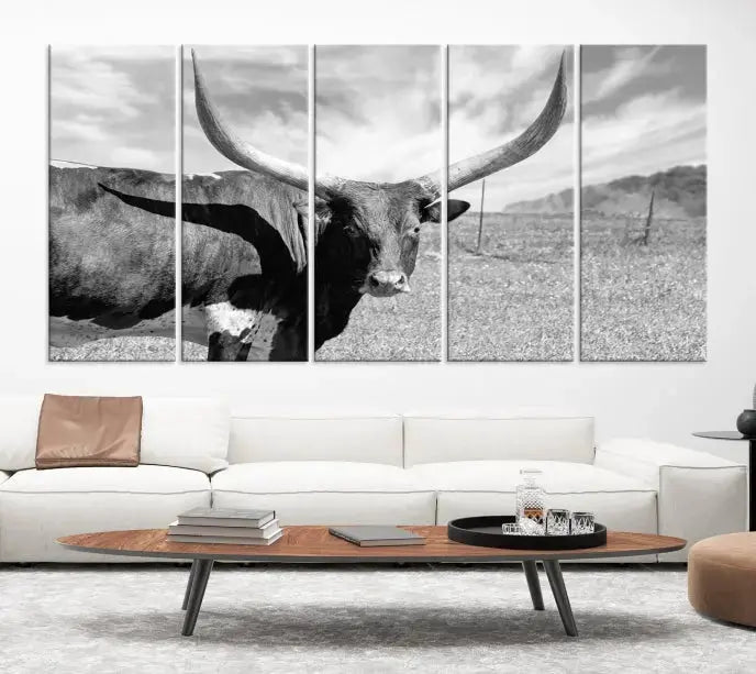 The Longhorn Wall Art Canvas Print, a black and white triptych of a longhorn cow in a grassy field, is elegantly displayed on museum-quality canvases.