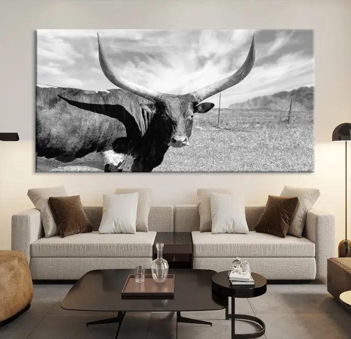 The Longhorn Wall Art Canvas Print, a black and white triptych of a longhorn cow in a grassy field, is elegantly displayed on museum-quality canvases.