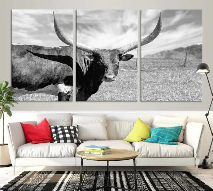 The Longhorn Wall Art Canvas Print, a black and white triptych of a longhorn cow in a grassy field, is elegantly displayed on museum-quality canvases.