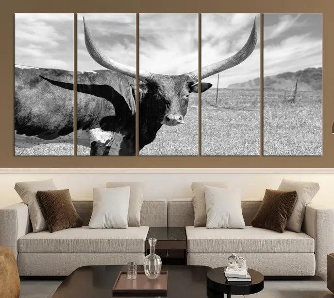 The Longhorn Wall Art Canvas Print, a black and white triptych of a longhorn cow in a grassy field, is elegantly displayed on museum-quality canvases.