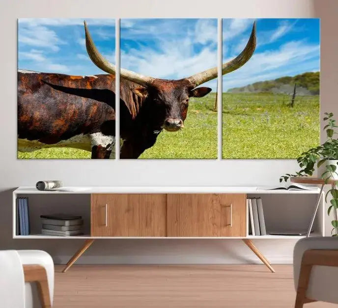 The Longhorn and Cow Wall Art Canvas Print features a triptych of a longhorn cow in a grassy field on a sunny day. These gallery-wrapped, museum-quality canvases are crafted by professional craftsmen to perfectly accentuate the scene, adding an exquisite touch to any living space.