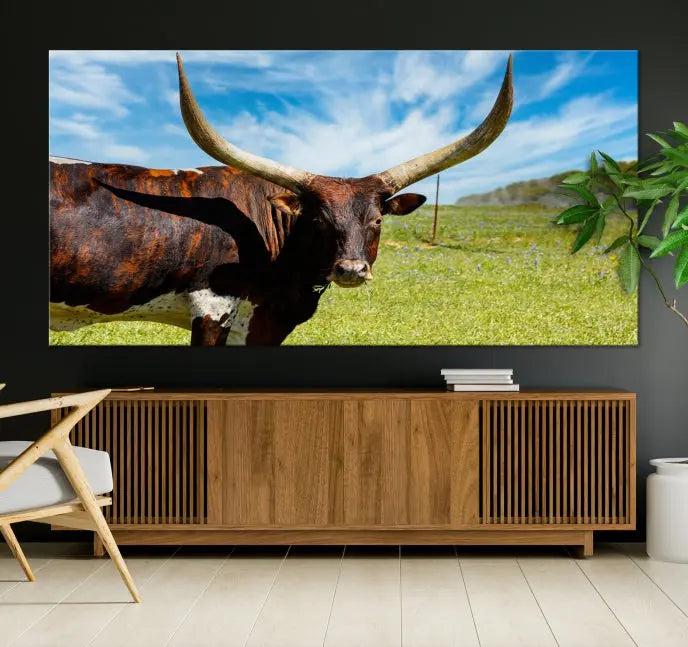 The Longhorn and Cow Wall Art Canvas Print features a triptych of a longhorn cow in a grassy field on a sunny day. These gallery-wrapped, museum-quality canvases are crafted by professional craftsmen to perfectly accentuate the scene, adding an exquisite touch to any living space.