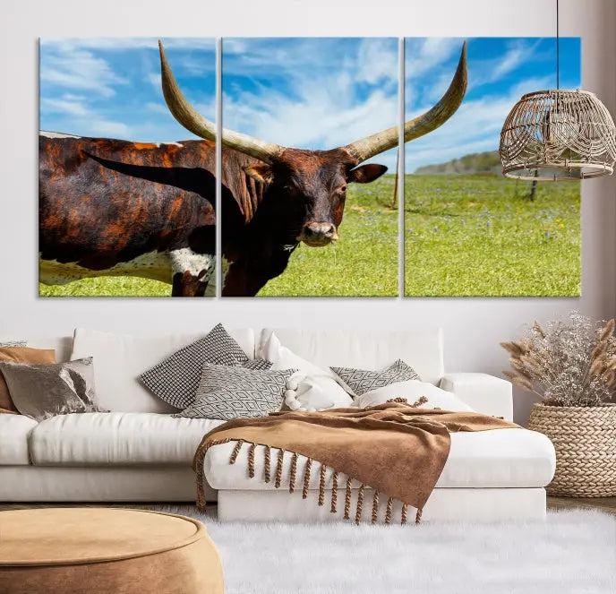 The Longhorn and Cow Wall Art Canvas Print features a triptych of a longhorn cow in a grassy field on a sunny day. These gallery-wrapped, museum-quality canvases are crafted by professional craftsmen to perfectly accentuate the scene, adding an exquisite touch to any living space.