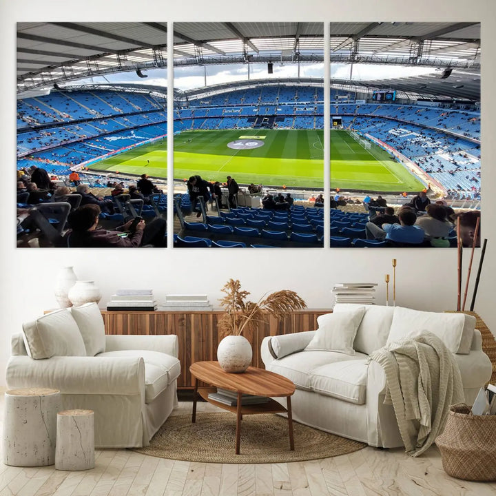 A captivating Manchester City Etihad Stadium Wall Art Canvas Print graces the living room, showcasing a football stadium with an empty field in a gallery-quality finish.