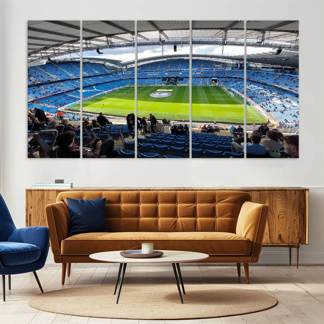 A captivating Manchester City Etihad Stadium Wall Art Canvas Print graces the living room, showcasing a football stadium with an empty field in a gallery-quality finish.