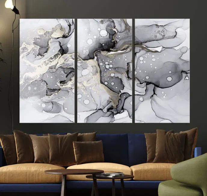 The "Marble Fluid Effect Wall Art Abstract Canvas Wall Art Print" forms a stunning abstract triptych with black, gray, and gold patterns in a modern living room. These museum-quality pieces include a UV-protective coating to ensure lasting beauty.