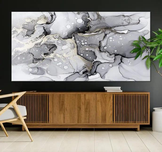 The "Marble Fluid Effect Wall Art Abstract Canvas Wall Art Print" forms a stunning abstract triptych with black, gray, and gold patterns in a modern living room. These museum-quality pieces include a UV-protective coating to ensure lasting beauty.