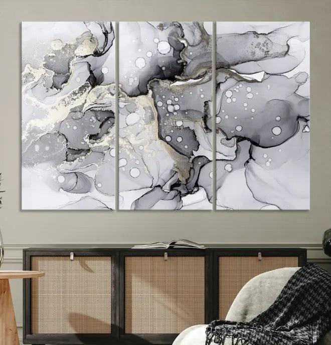 The "Marble Fluid Effect Wall Art Abstract Canvas Wall Art Print" forms a stunning abstract triptych with black, gray, and gold patterns in a modern living room. These museum-quality pieces include a UV-protective coating to ensure lasting beauty.