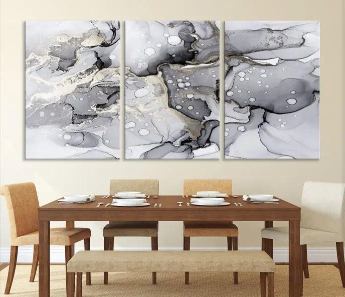 The "Marble Fluid Effect Wall Art Abstract Canvas Wall Art Print" forms a stunning abstract triptych with black, gray, and gold patterns in a modern living room. These museum-quality pieces include a UV-protective coating to ensure lasting beauty.