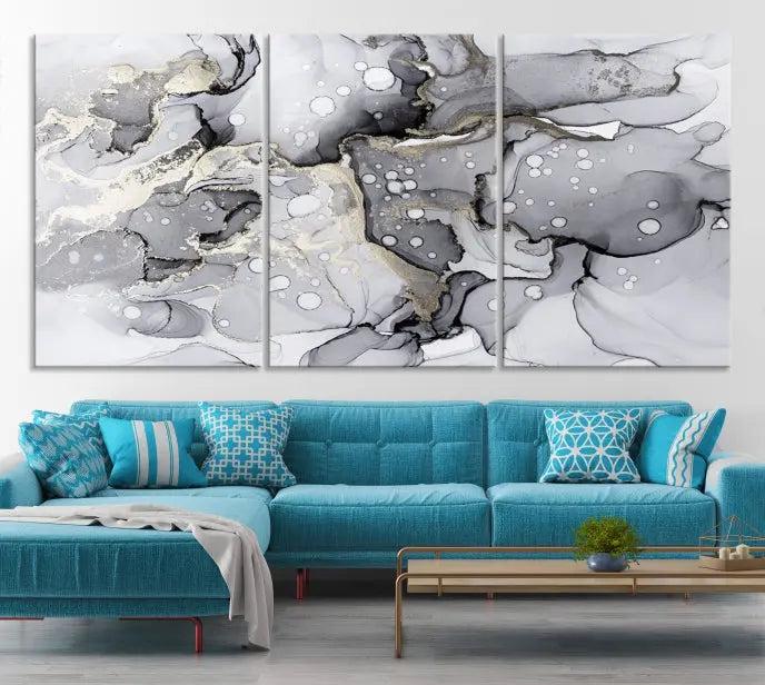 The "Marble Fluid Effect Wall Art Abstract Canvas Wall Art Print" forms a stunning abstract triptych with black, gray, and gold patterns in a modern living room. These museum-quality pieces include a UV-protective coating to ensure lasting beauty.