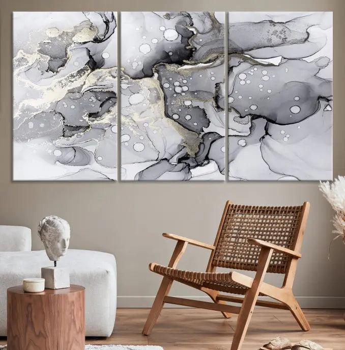 The "Marble Fluid Effect Wall Art Abstract Canvas Wall Art Print" forms a stunning abstract triptych with black, gray, and gold patterns in a modern living room. These museum-quality pieces include a UV-protective coating to ensure lasting beauty.