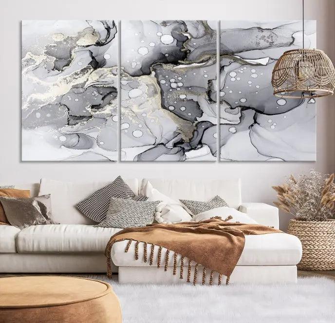 The "Marble Fluid Effect Wall Art Abstract Canvas Wall Art Print" forms a stunning abstract triptych with black, gray, and gold patterns in a modern living room. These museum-quality pieces include a UV-protective coating to ensure lasting beauty.