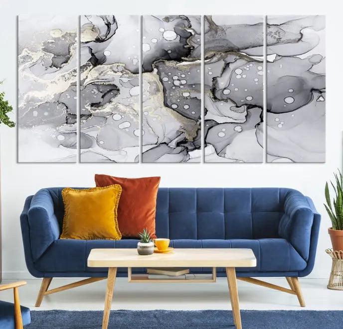 The "Marble Fluid Effect Wall Art Abstract Canvas Wall Art Print" forms a stunning abstract triptych with black, gray, and gold patterns in a modern living room. These museum-quality pieces include a UV-protective coating to ensure lasting beauty.